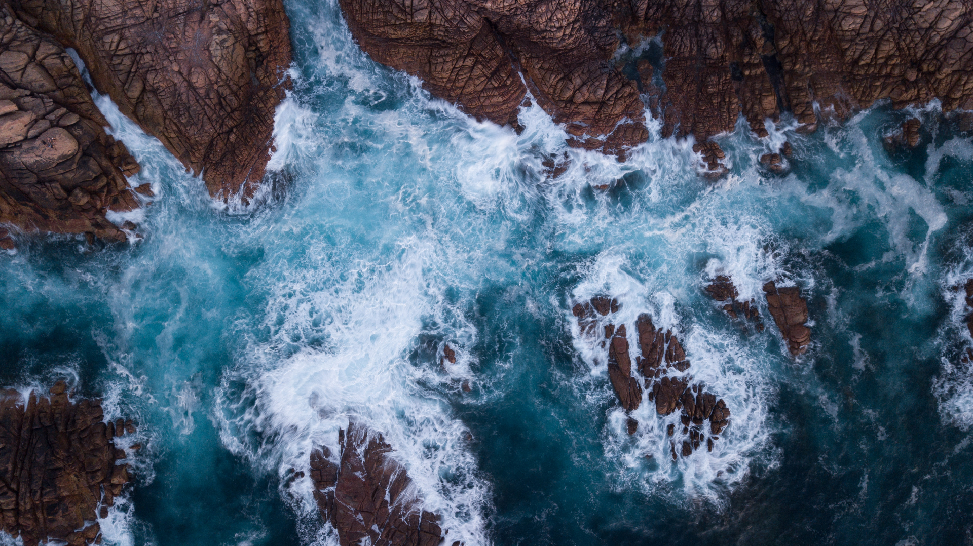 Aerial view of a rugged Western Australian coastline with waves breaking on rock